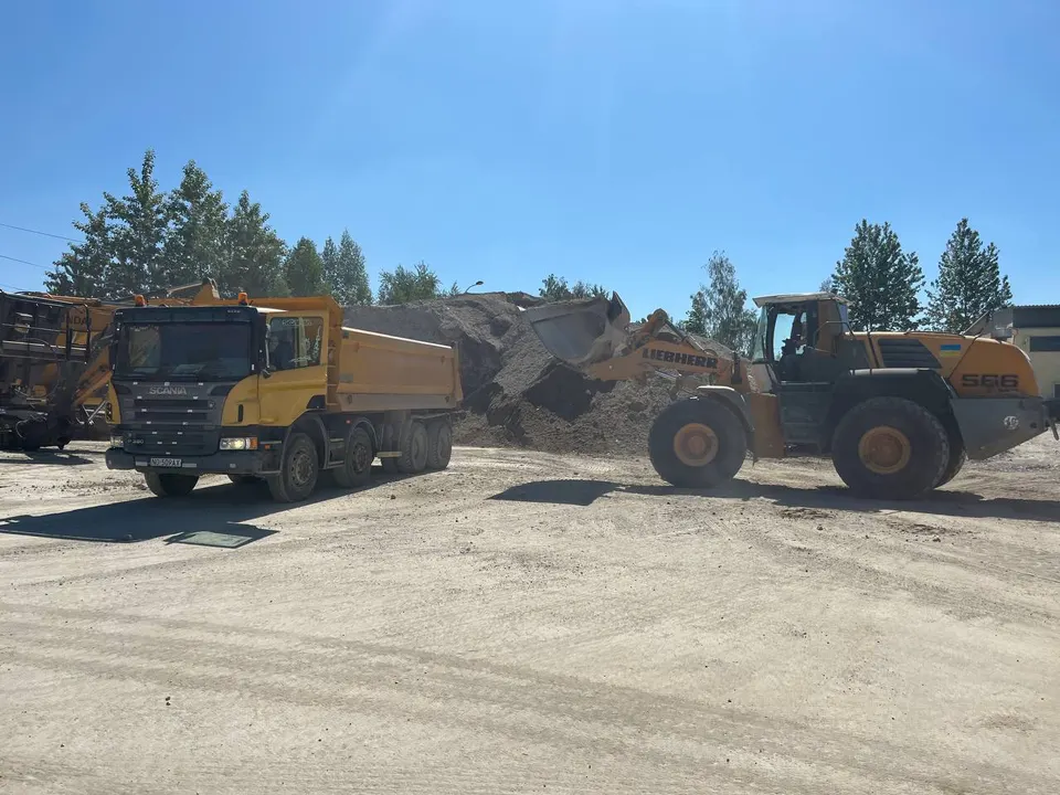 Ładowarka kołowa Liebherr 566 ładująca materiał sypki na wywrotkę Scania