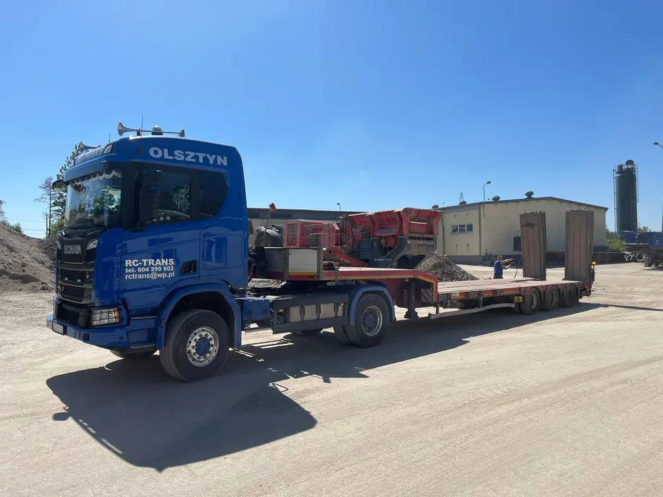 Scania z naczepą niskopodwoziową i mobilna kruszarka Terex Finlay na placu